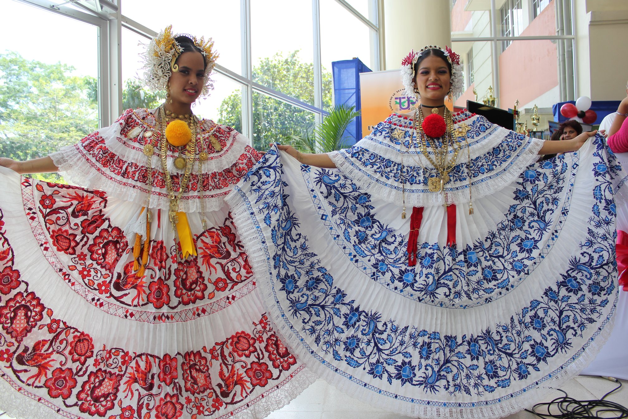 Two young women spread the skirts of their polleras de gala, one embroidered in red, the other in blue, 2012