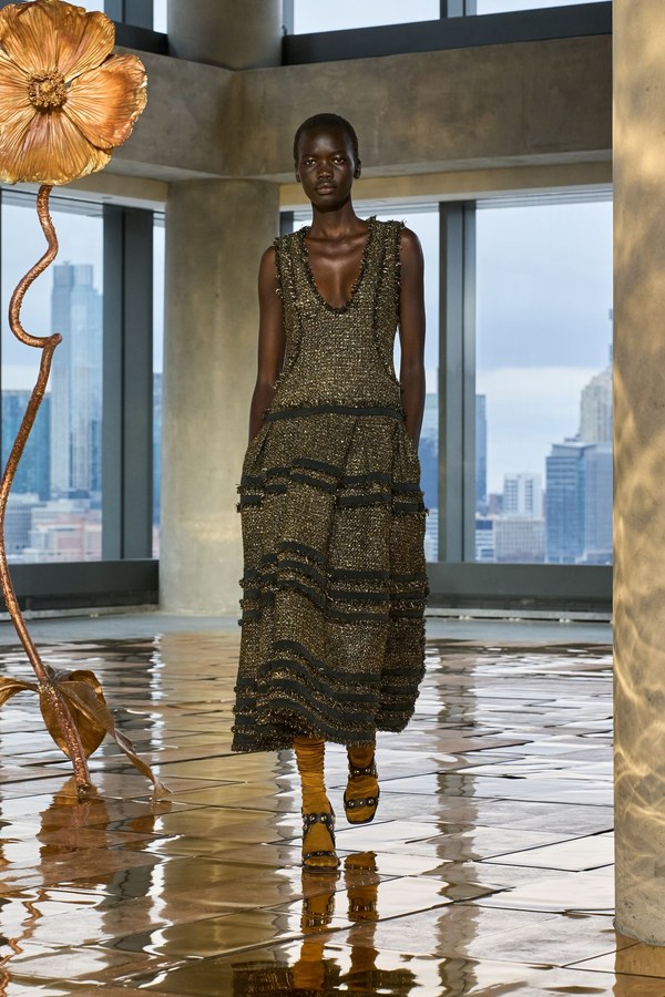 Ulla Johnson Fall 2025, look 2: gold-shot tweed midi dress made of horizontal tiers with fringed seams